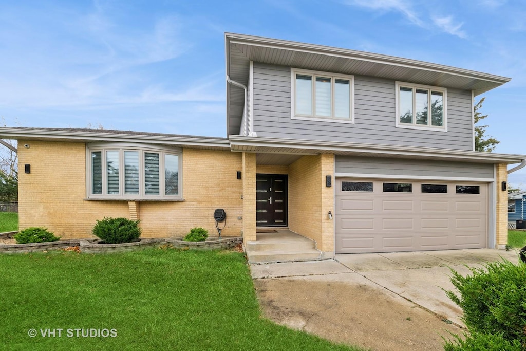 view of front of property featuring a garage and a front lawn