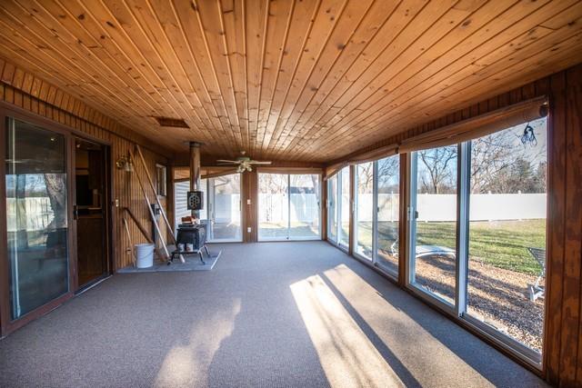 unfurnished sunroom featuring ceiling fan and wooden ceiling