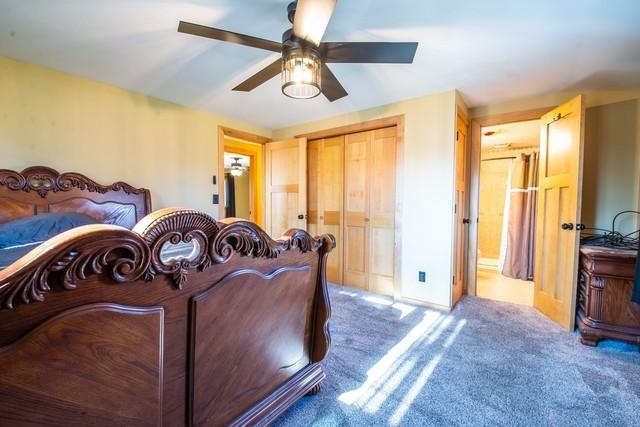 carpeted bedroom featuring a closet and ceiling fan