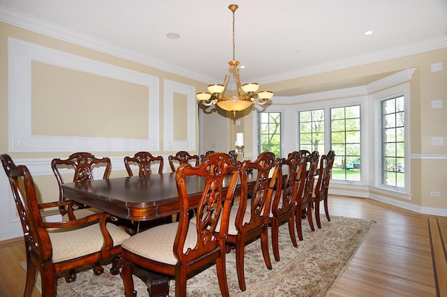 dining room with crown molding, light hardwood / wood-style flooring, and a notable chandelier