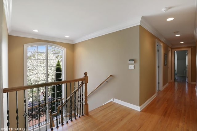 corridor with hardwood / wood-style flooring and ornamental molding