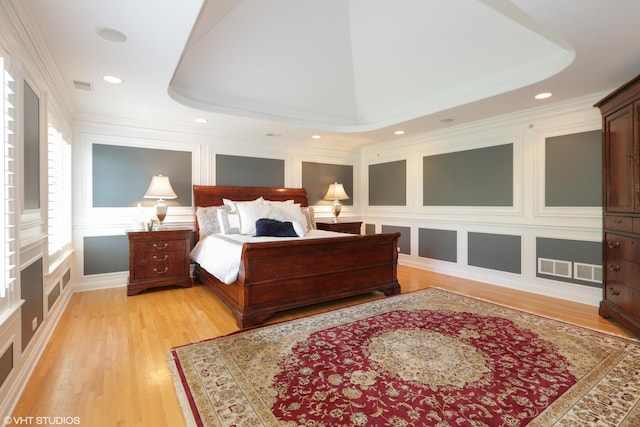 bedroom featuring crown molding and light hardwood / wood-style flooring