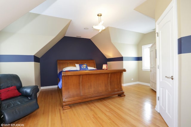 bedroom featuring vaulted ceiling and light wood-type flooring