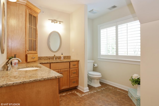 bathroom featuring tile patterned flooring, vanity, and toilet