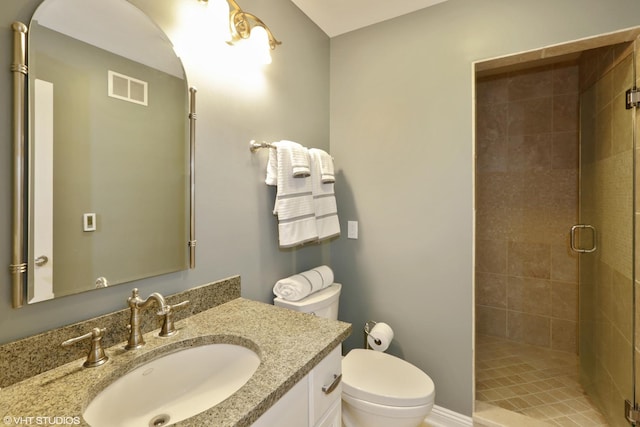 bathroom featuring vanity, an enclosed shower, and toilet