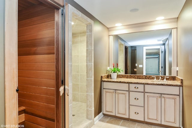 bathroom with vanity, tile patterned flooring, and a tile shower