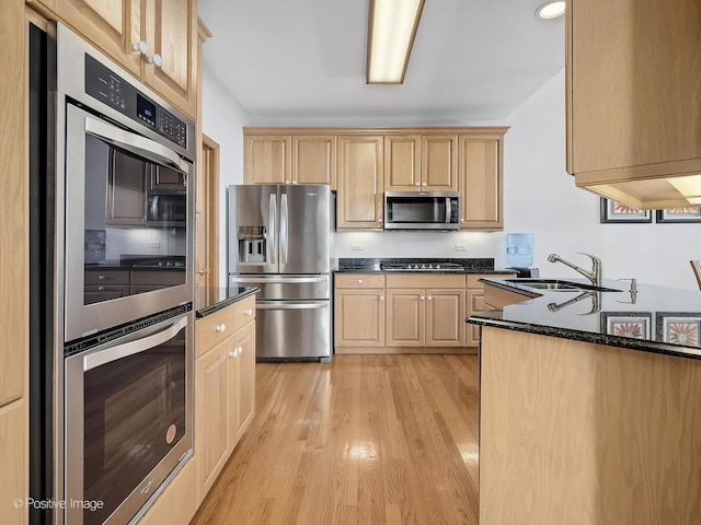 kitchen featuring light brown cabinets, sink, light wood-type flooring, and stainless steel appliances