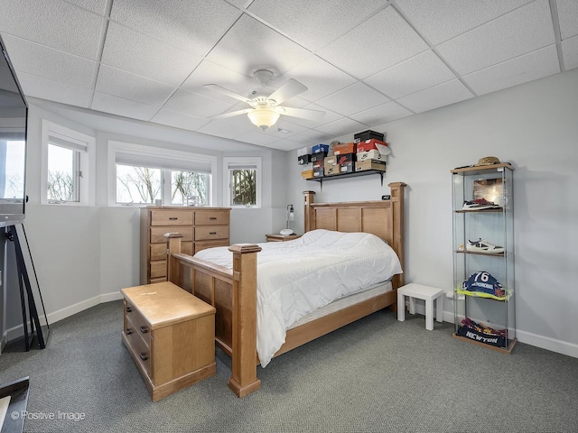 carpeted bedroom featuring a drop ceiling and ceiling fan