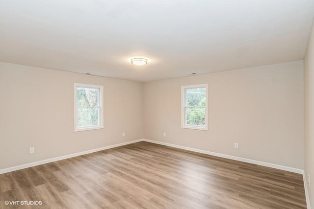 empty room featuring a healthy amount of sunlight and hardwood / wood-style flooring