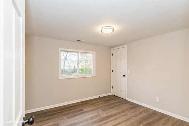 unfurnished room featuring dark wood-type flooring