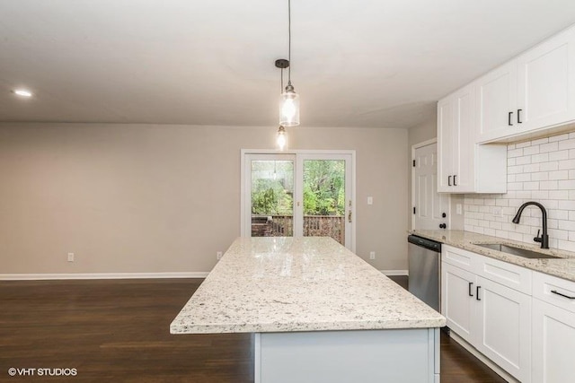 kitchen featuring a center island, decorative light fixtures, white cabinetry, and sink