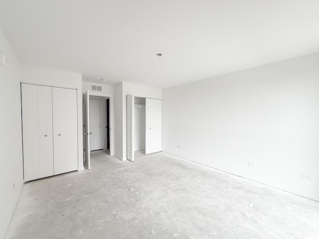 unfurnished bedroom with two closets