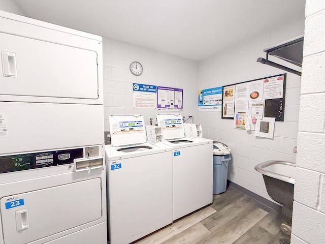 clothes washing area with stacked washer / drying machine, independent washer and dryer, and light hardwood / wood-style flooring