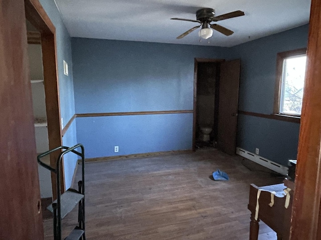 spare room with hardwood / wood-style flooring, ceiling fan, and a baseboard heating unit