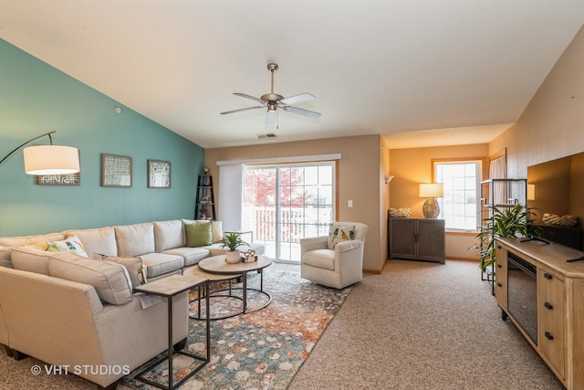 carpeted living room with lofted ceiling, ceiling fan, and a healthy amount of sunlight