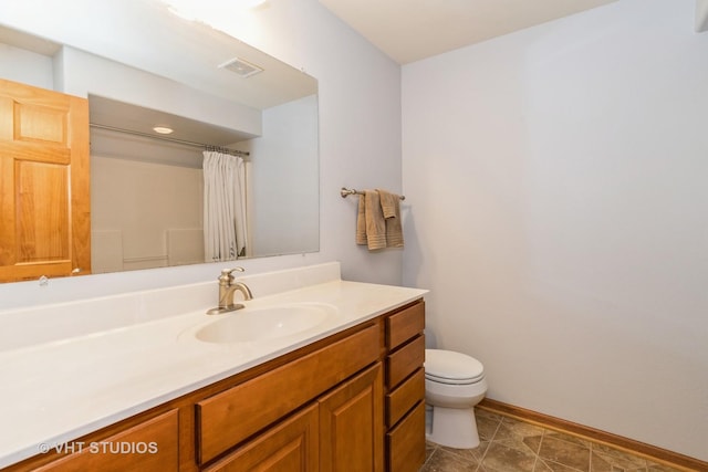 bathroom featuring tile patterned flooring, vanity, toilet, and walk in shower