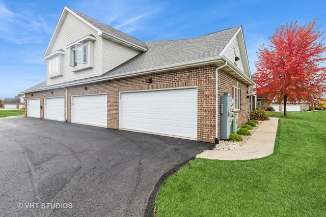 view of side of property with a garage and a lawn