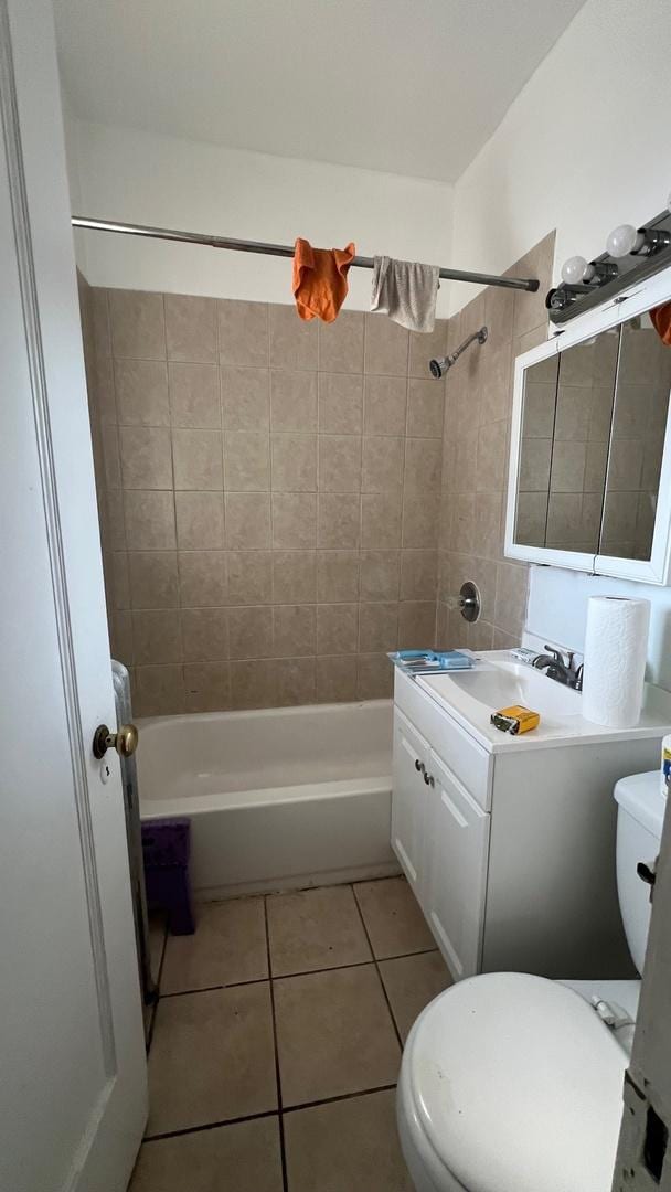 full bathroom featuring tile patterned floors, vanity, toilet, and tiled shower / bath combo