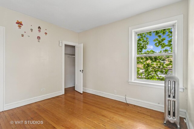 7730 S E End Ave, Chicago, IL 60649 - unfurnished bedroom featuring light wood finished floors, baseboards, and radiator heating unit