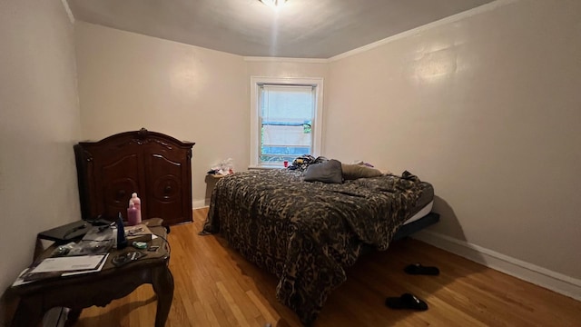 bedroom with light hardwood / wood-style floors and ornamental molding