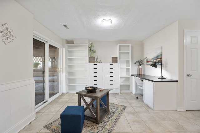 office space with light tile patterned floors, a textured ceiling, and visible vents