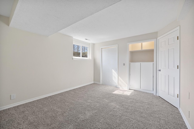 unfurnished bedroom with carpet, a closet, a textured ceiling, and baseboards