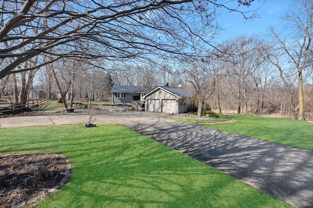 view of front facade with an attached garage, aphalt driveway, and a front yard