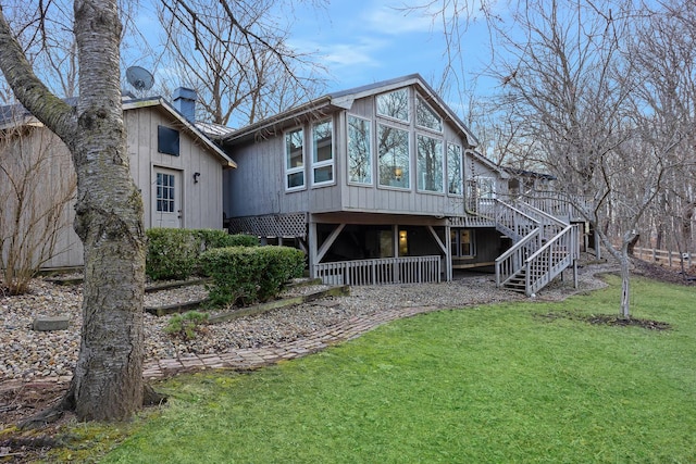 view of front of home featuring a deck, a front yard, a chimney, and stairway