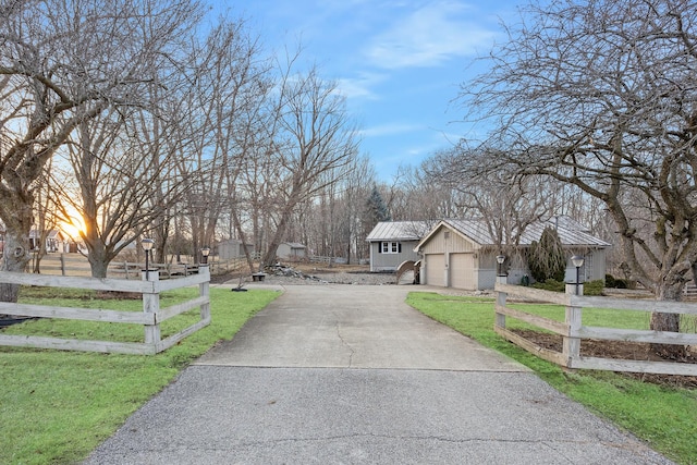 view of front facade featuring a fenced front yard, a standing seam roof, and driveway