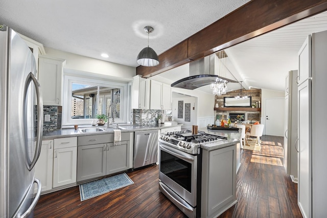 kitchen featuring lofted ceiling with beams, a kitchen island, appliances with stainless steel finishes, and dark wood finished floors