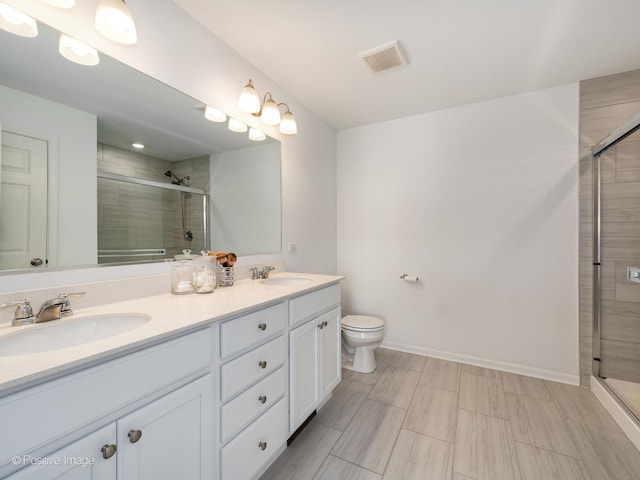 bathroom with vanity, toilet, and a shower with shower door