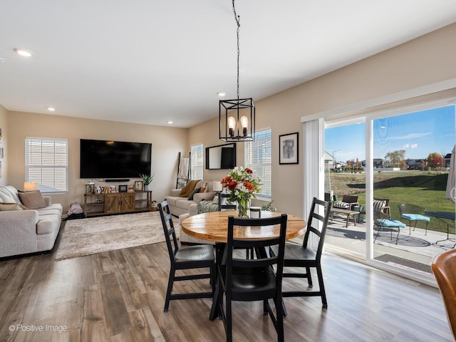 dining space with hardwood / wood-style floors and a chandelier