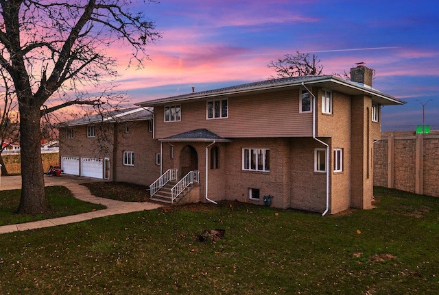 view of front of property featuring a garage, driveway, a chimney, fence, and a front lawn