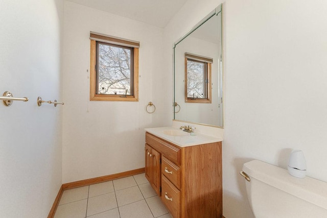 bathroom with tile patterned floors, a wealth of natural light, vanity, and toilet