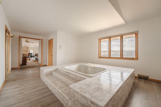 bathroom with tiled tub, ceiling fan, sink, and hardwood / wood-style flooring