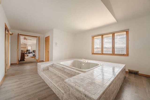 17043 Annetta Ave, Hazel Crest, IL 60429 - bathroom featuring a tub with jets, plenty of natural light, wood finished floors, and baseboards