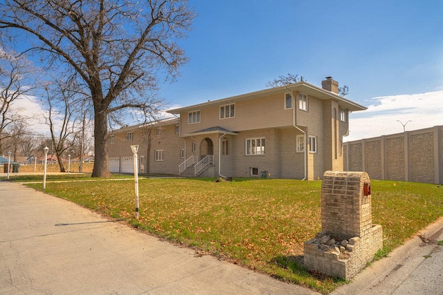 view of front of house featuring a garage and a front lawn