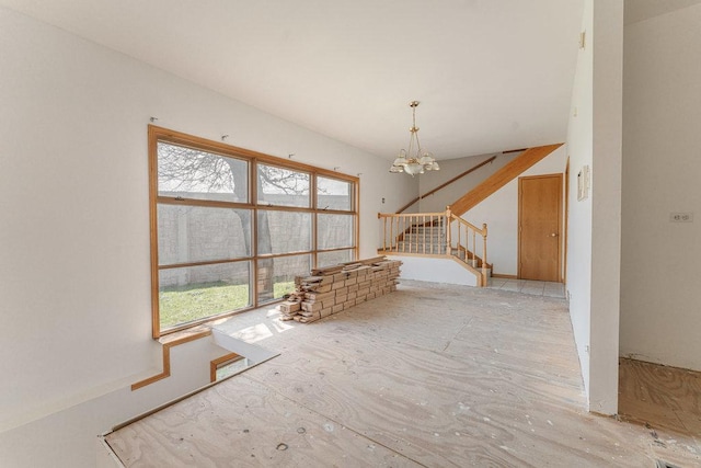 unfurnished living room with stairs and a notable chandelier