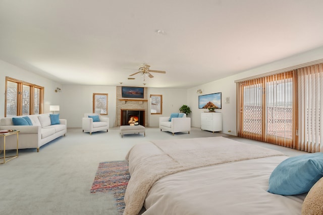 carpeted bedroom with ceiling fan and a fireplace