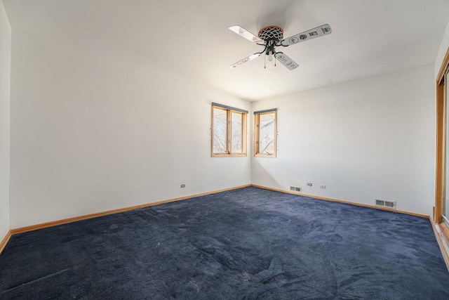 carpeted spare room with visible vents, ceiling fan, and baseboards