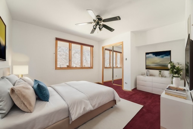 carpeted bedroom with ceiling fan and a closet