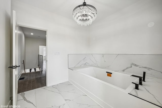 bathroom with a chandelier and a washtub