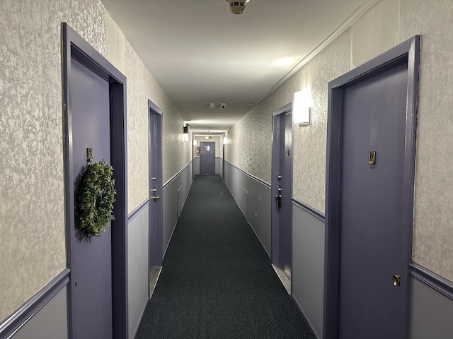 corridor with dark carpet and ornamental molding