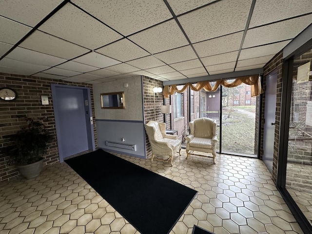 interior space with a paneled ceiling and baseboard heating