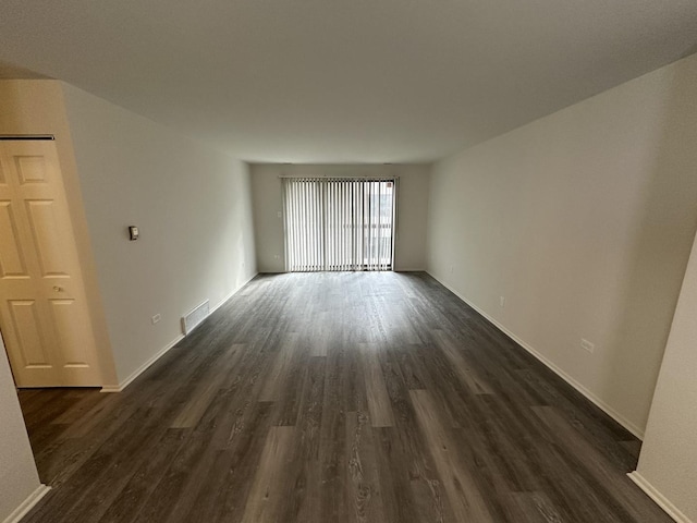 unfurnished room with dark wood-type flooring