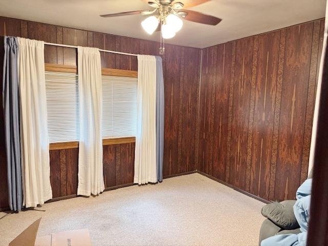 1429 N Wolf Rd, Berkeley, IL 60163 - carpeted empty room featuring ceiling fan and wooden walls