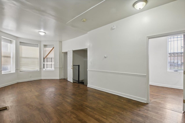 empty room with dark hardwood / wood-style flooring