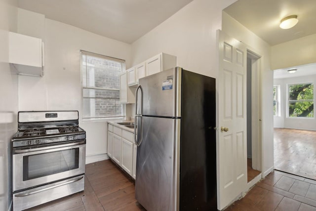 kitchen with white cabinets, dark hardwood / wood-style floors, and appliances with stainless steel finishes