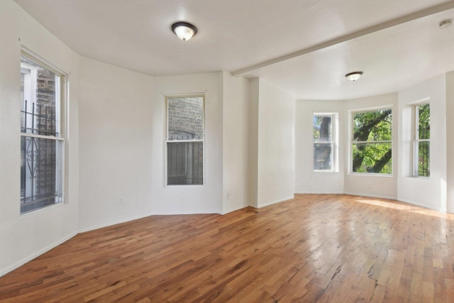 unfurnished room with hardwood / wood-style flooring