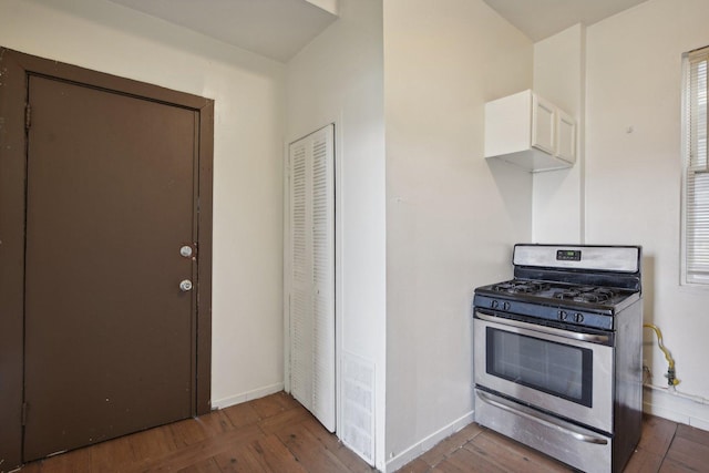 kitchen with white cabinets, dark hardwood / wood-style flooring, and stainless steel gas range oven